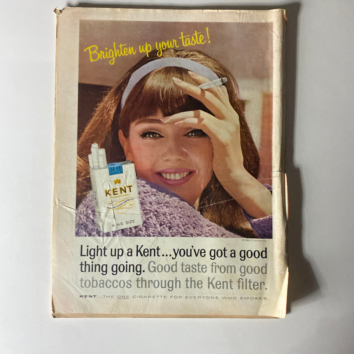Back cover advertisement of Time Magazine from November 5, 1965, showcasing a vintage Kent cigarette ad featuring a woman with a cigarette, promoting the product with the tagline 'Brighten up your taste!'