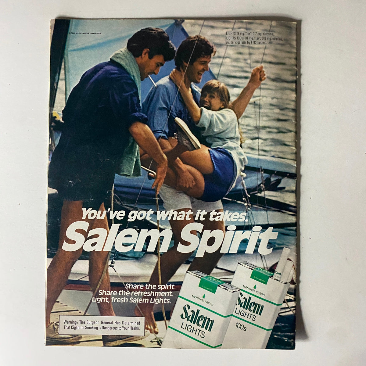 Vintage advertisement from Moviegoer Magazine July 1982 featuring friends enjoying a sailing day, promoting Salem Lights cigarettes.