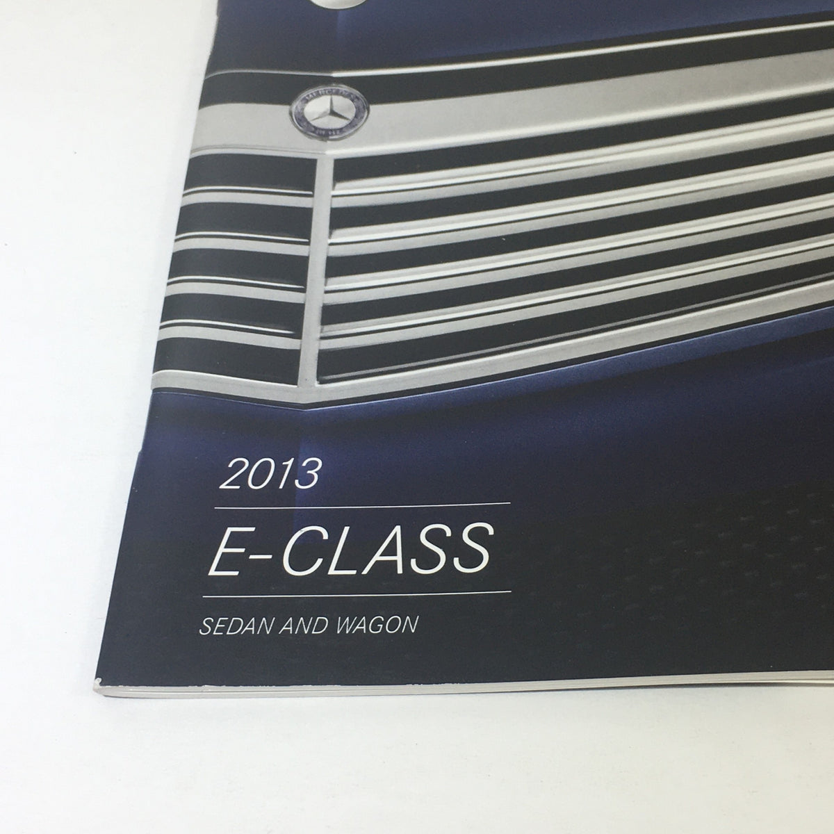 Close-up of the 2013 Mercedes-Benz E-Class Sedan and Wagon Dealership Car Auto Brochure highlighting the E-Class title.