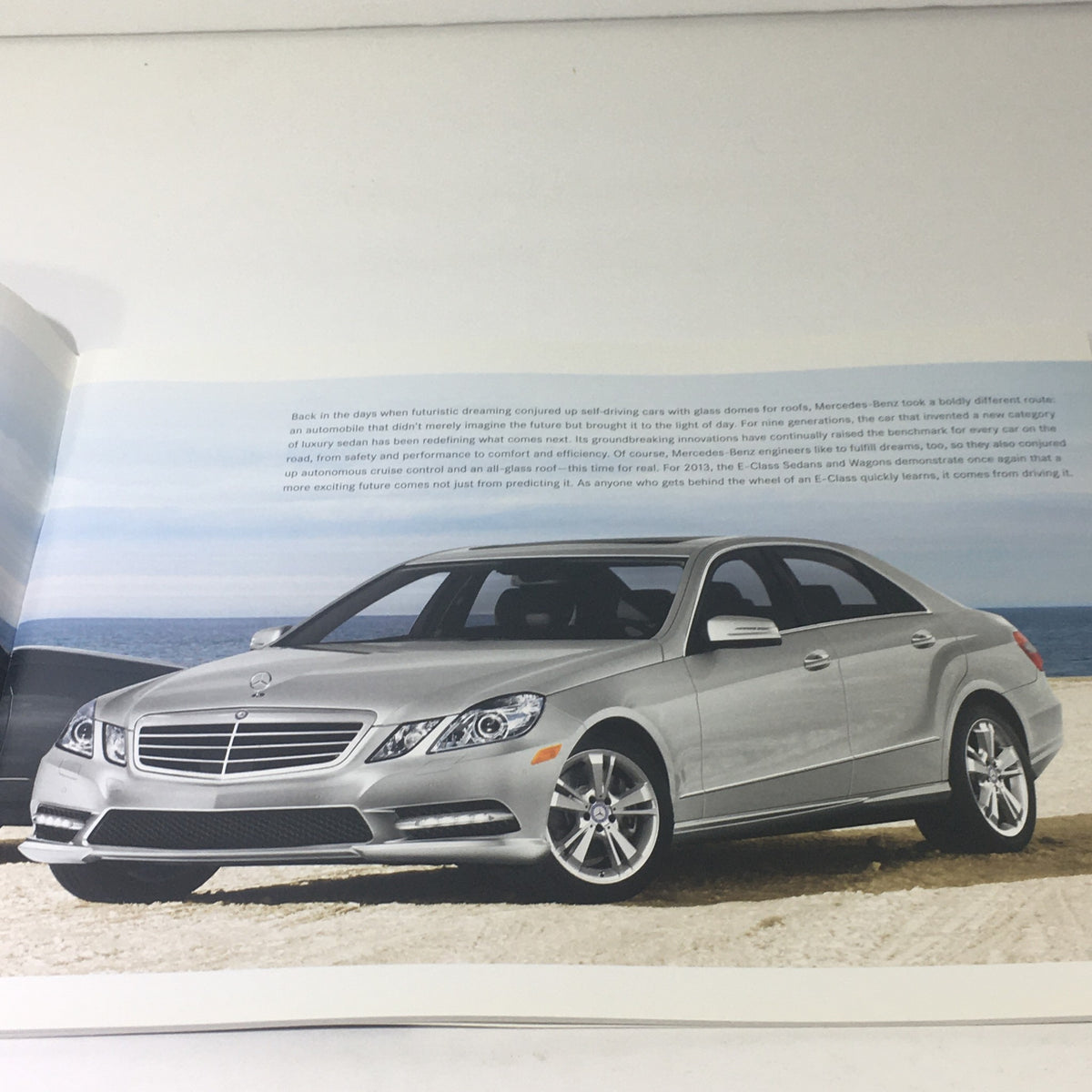 Interior page of the 2013 Mercedes-Benz E-Class Sedan and Wagon Dealership Car Auto Brochure displaying a silver E-Class model on the beach.