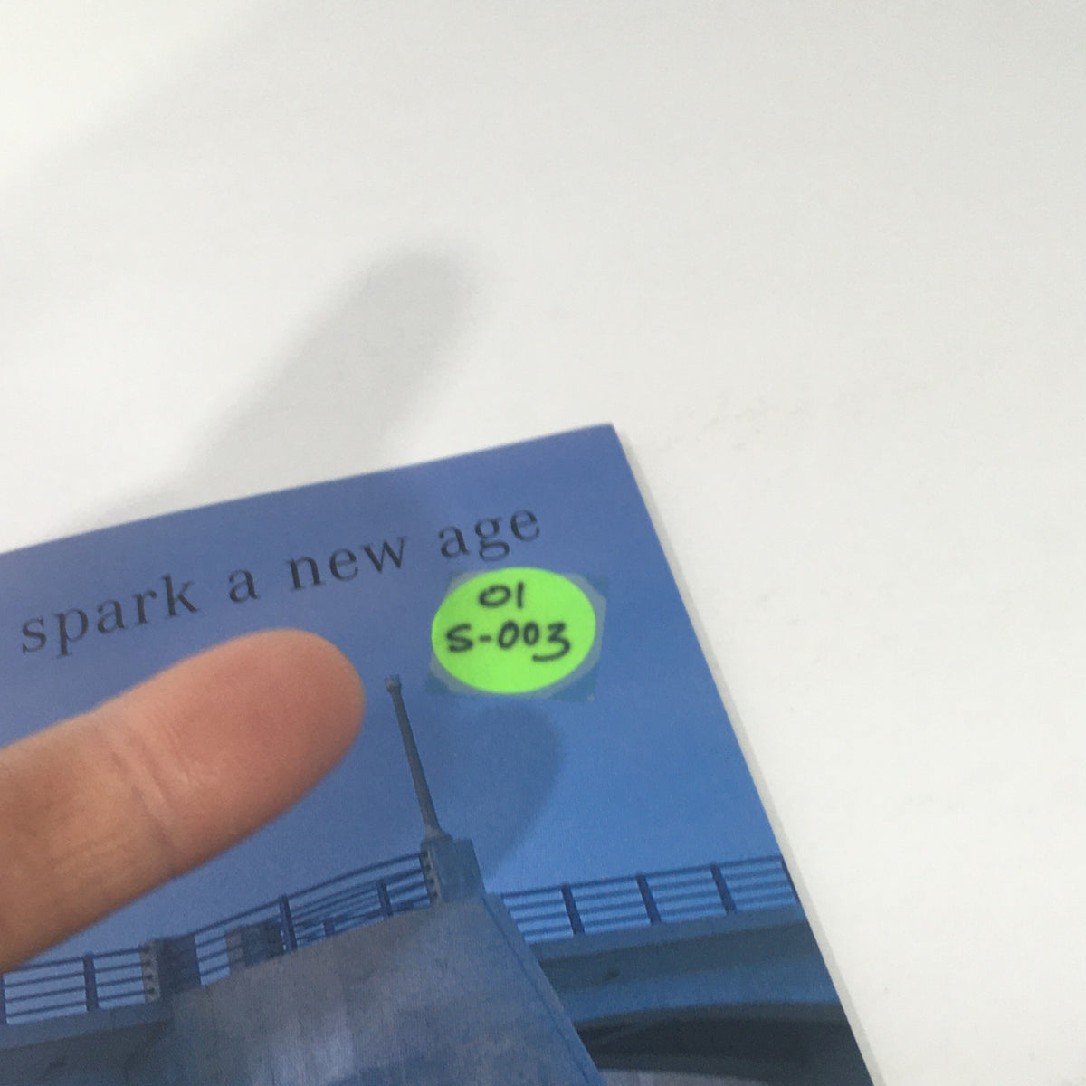 Close-up of 2001 Mercedes-Benz S-Class Dealership Car Auto Brochure Catalog showcasing a page with a plastic label marker and finger pointing, indicating page S-003.