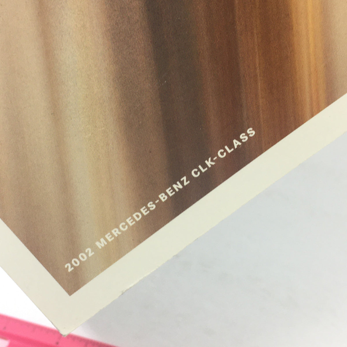 Close-up of the corner of the 2002 Mercedes-Benz CLK-Class Dealership Car Auto Brochure Catalog showing the embossed title and logo.