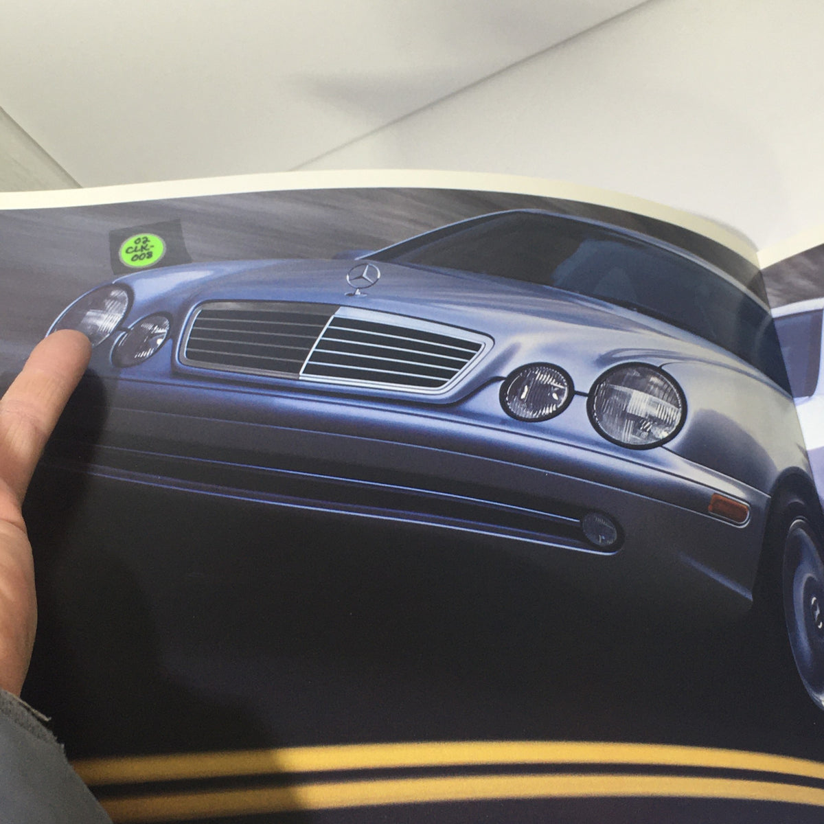 Interior page of the 2002 Mercedes-Benz CLK-Class Dealership Car Auto Brochure showcasing a silver Mercedes-Benz CLK-Class on the road.