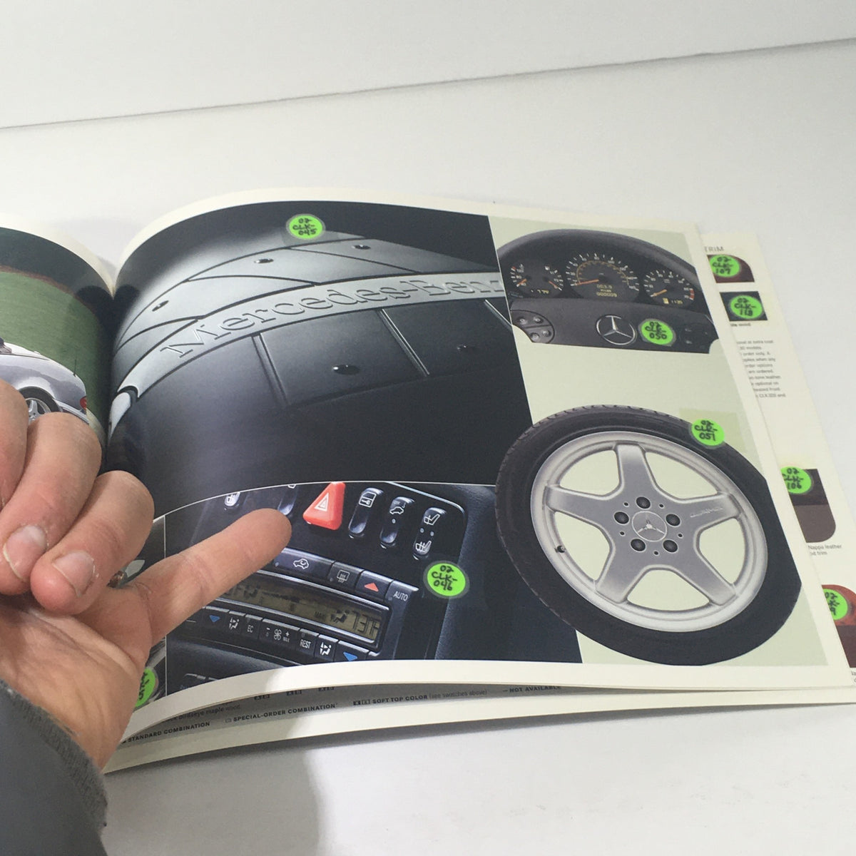 Interior page of the 2002 Mercedes-Benz CLK-Class Dealership Car Auto Brochure highlighting detailed images of the car's interior features and controls.