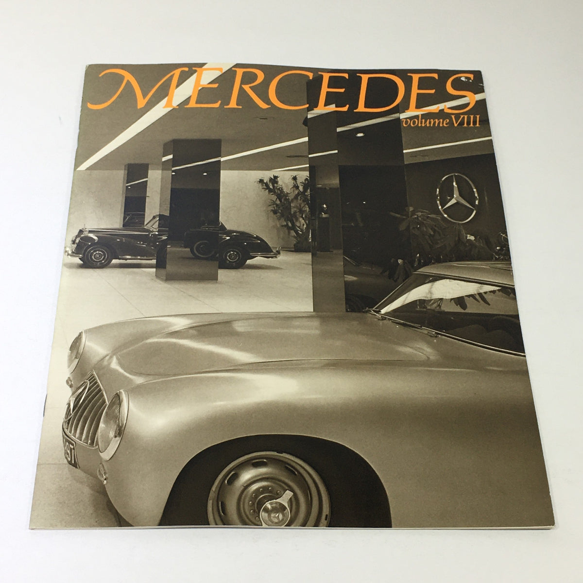 Cover image of the 1983 Mercedes-Benz Volume VIII Dealership Car Auto Brochure Catalog, featuring sleek vintage cars in a showroom setting.