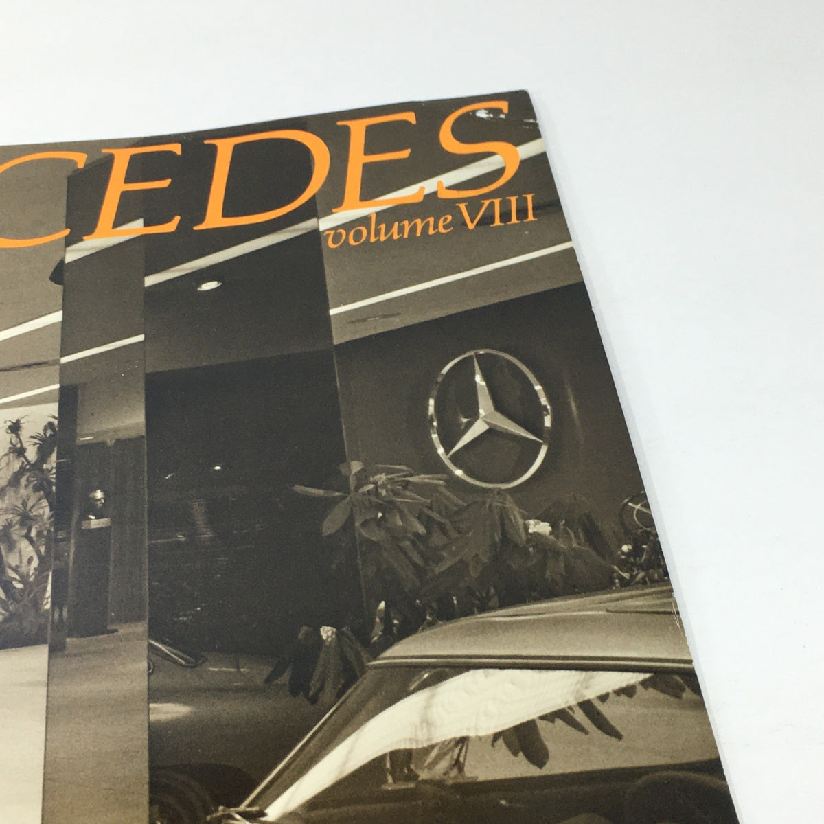 Close-up view of the cover of the 1983 Mercedes-Benz Volume VIII Dealership Car Auto Brochure Catalog, highlighting the brand name and logo against a stylish backdrop.