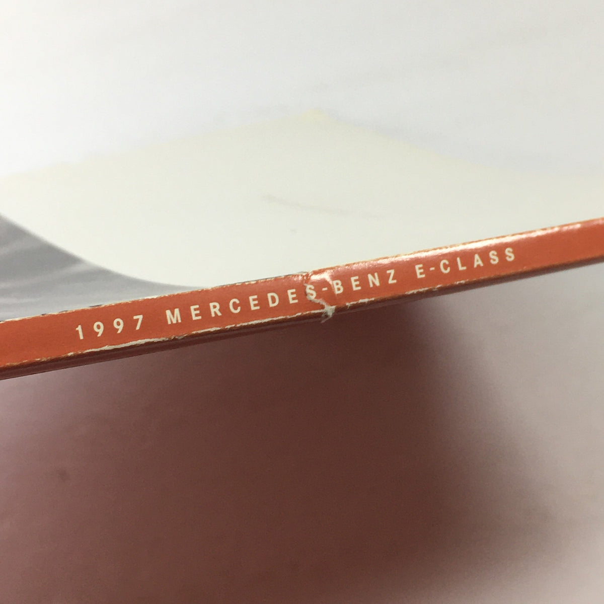 Side view of the 1997 Mercedes-Benz E Class Coupe Dealership Car Auto Brochure Catalog showing the spine with the text '1997 MERCEDES-BENZ E-CLASS'.