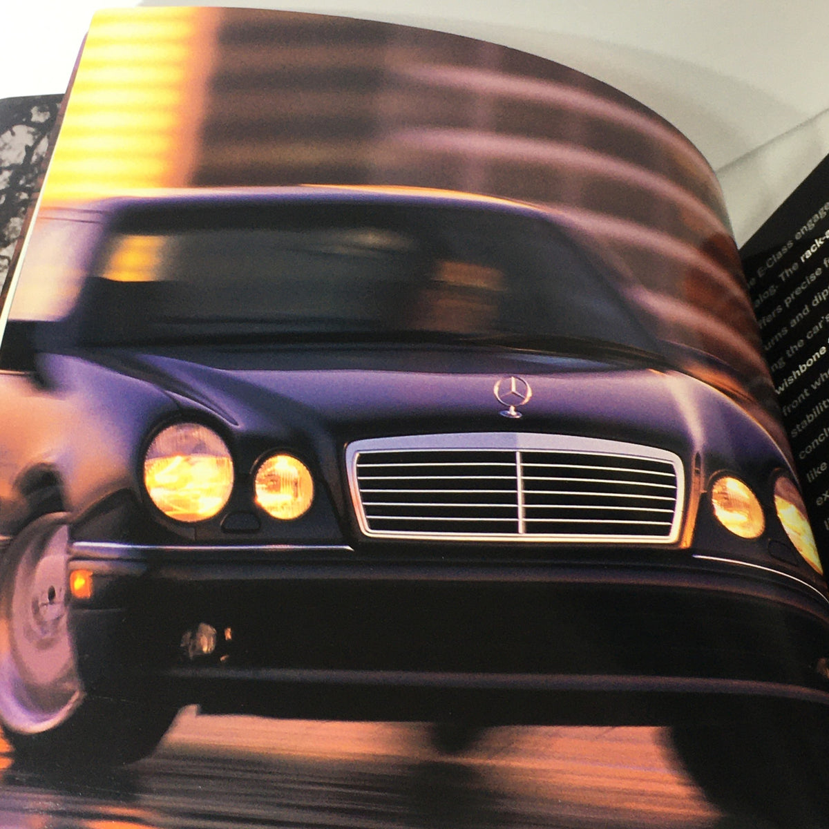 Dynamic shot of a 1997 Mercedes-Benz E Class Coupe in motion, highlighted in the dealership car auto brochure catalog, emphasizing its sleek design and performance.