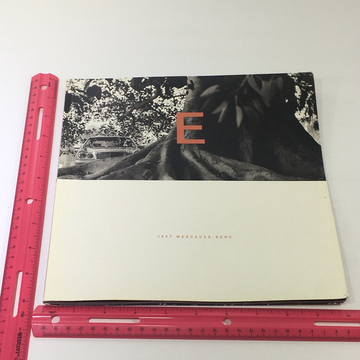Front cover of the 1997 Mercedes-Benz E Class Coupe Dealership Car Auto Brochure Catalog, showing an artistic design with the letter 'E' and a tree.