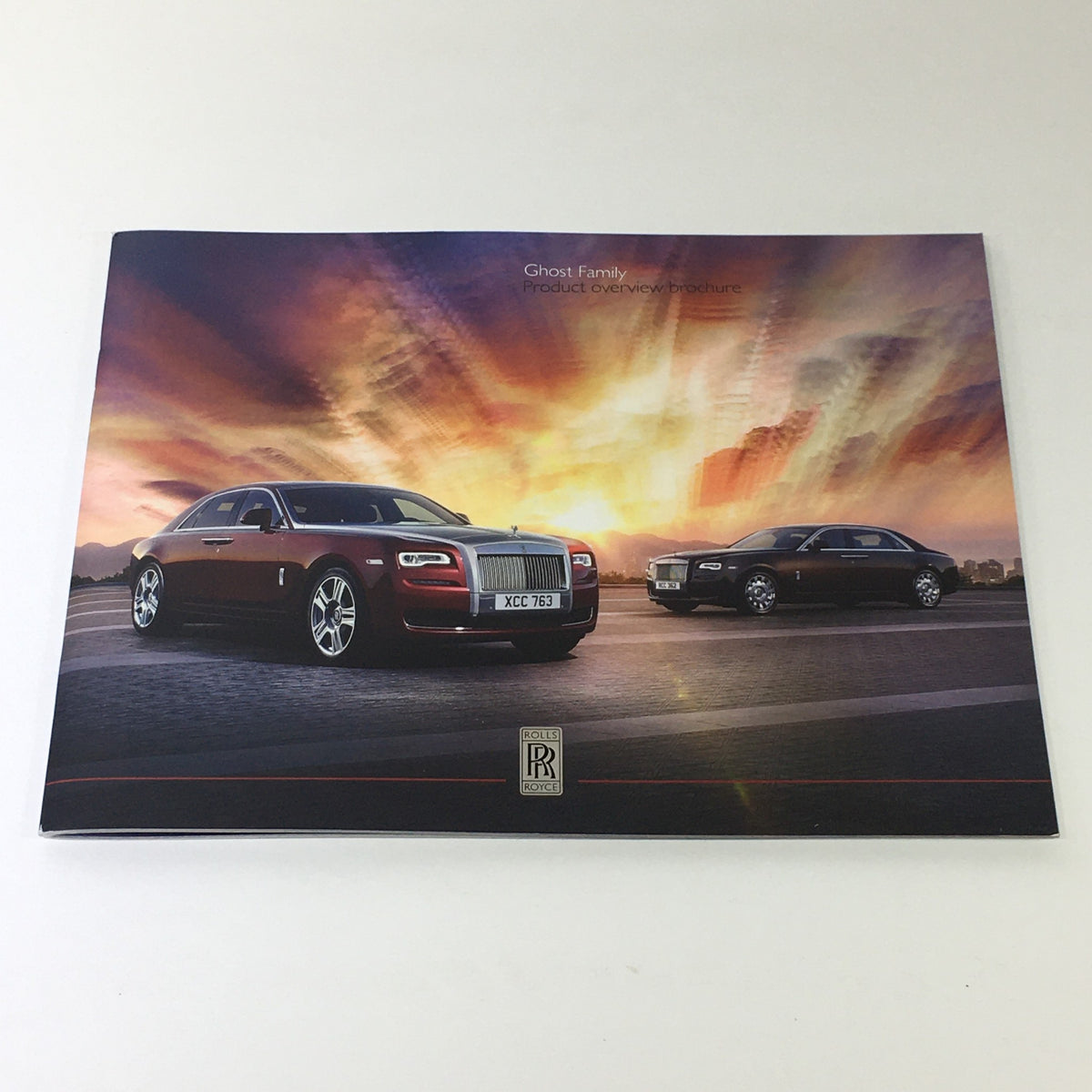 2014 Rolls Royce Ghost Family Dealership Car Auto Brochure Catalog showcasing two luxury cars with a dramatic sunset background.