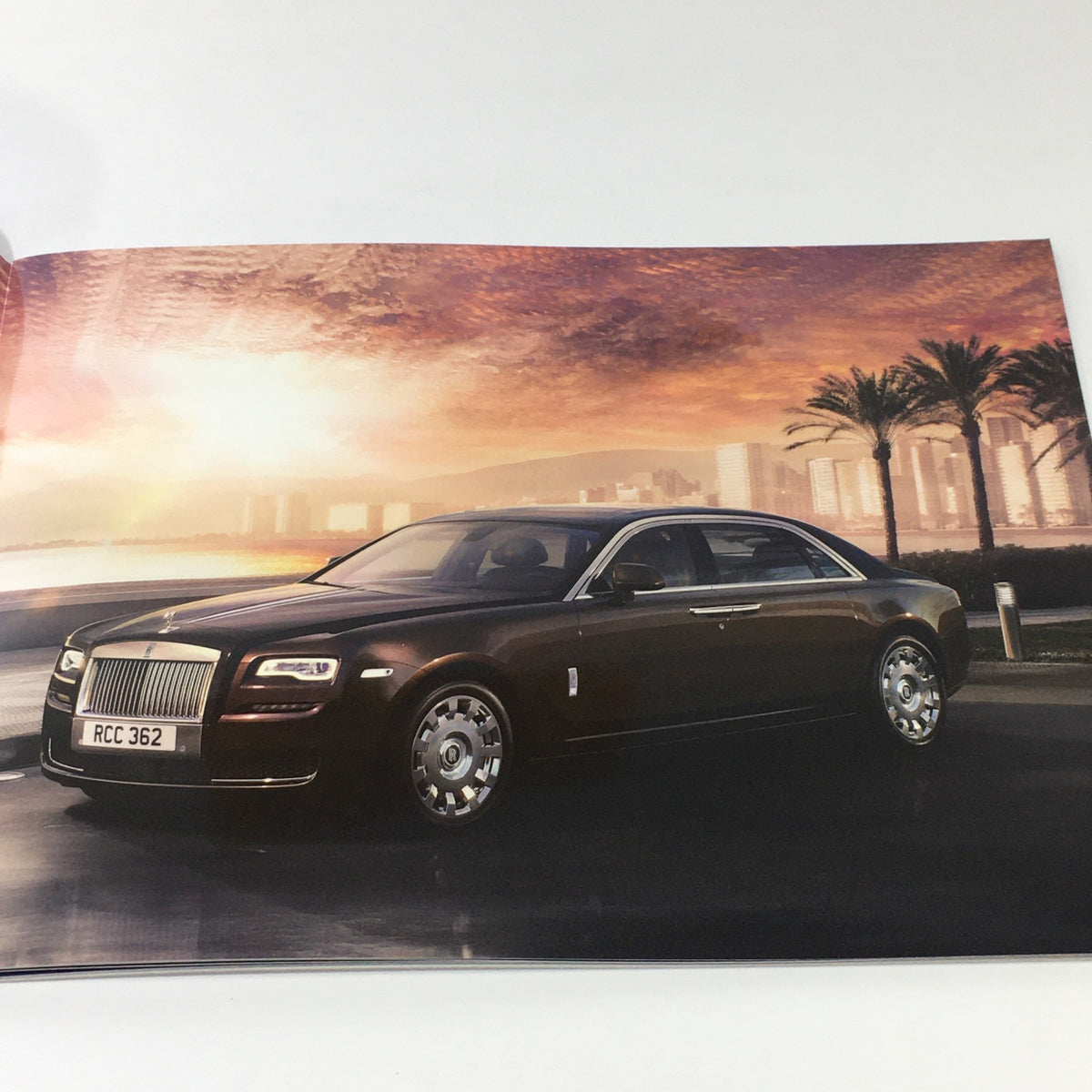 2014 Rolls Royce Ghost Family Dealership Car Auto Brochure Catalog showcasing the luxurious Rolls Royce Ghost parked against a scenic sunset backdrop.