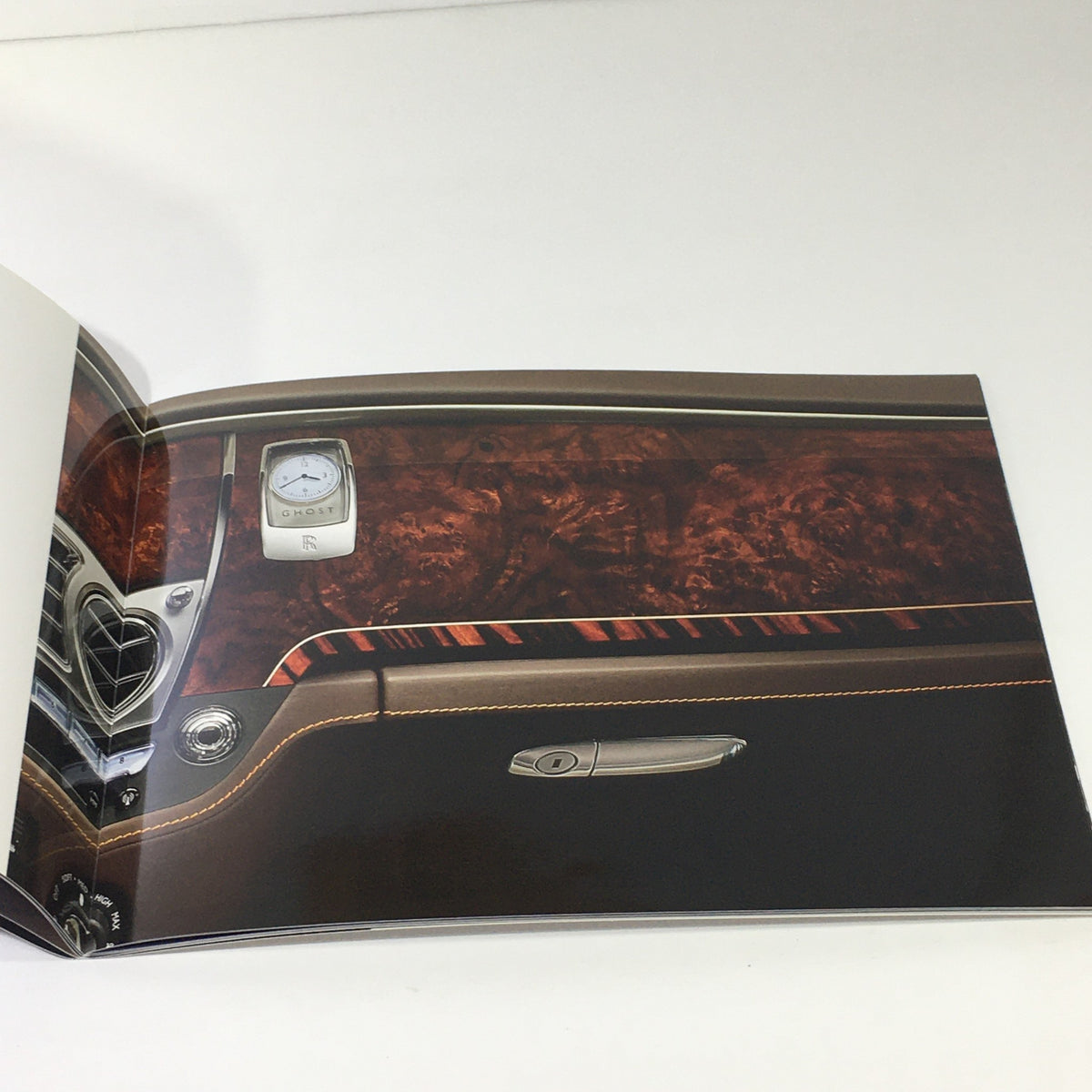 Close-up of the interior detailing in the 2014 Rolls Royce Ghost Family Dealership Car Auto Brochure Catalog, highlighting fine wood finishes and luxury design.