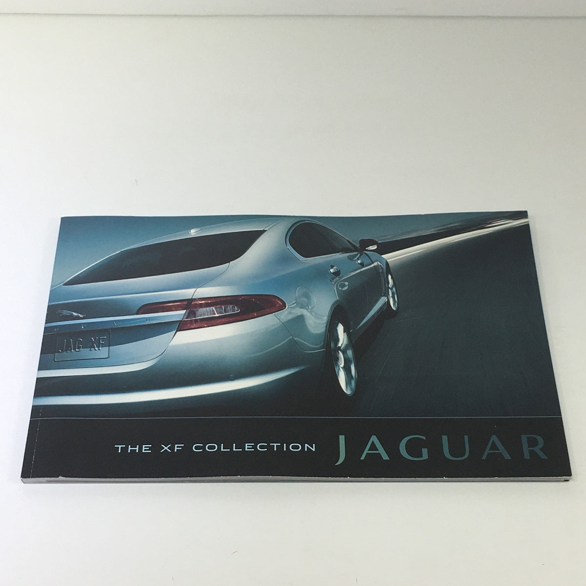 2010 Jaguar The XF Collection Dealership Car Auto Brochure Catalog showing the sleek rear design of the Jaguar XF with a modern highway backdrop.