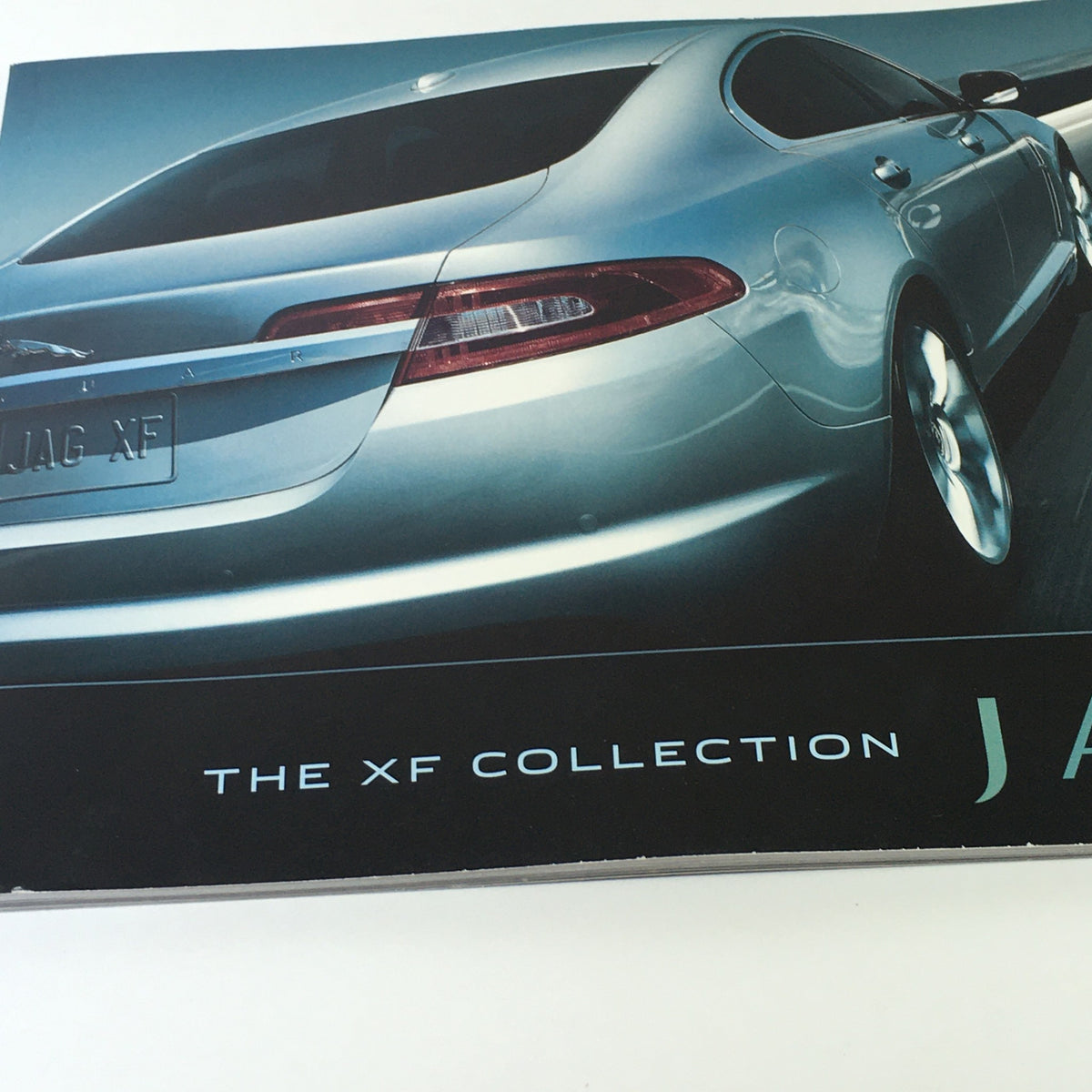 2010 Jaguar The XF Collection Dealership Car Auto Brochure Catalog highlighting the elegant rear view of the Jaguar XF with a focus on its premium features.