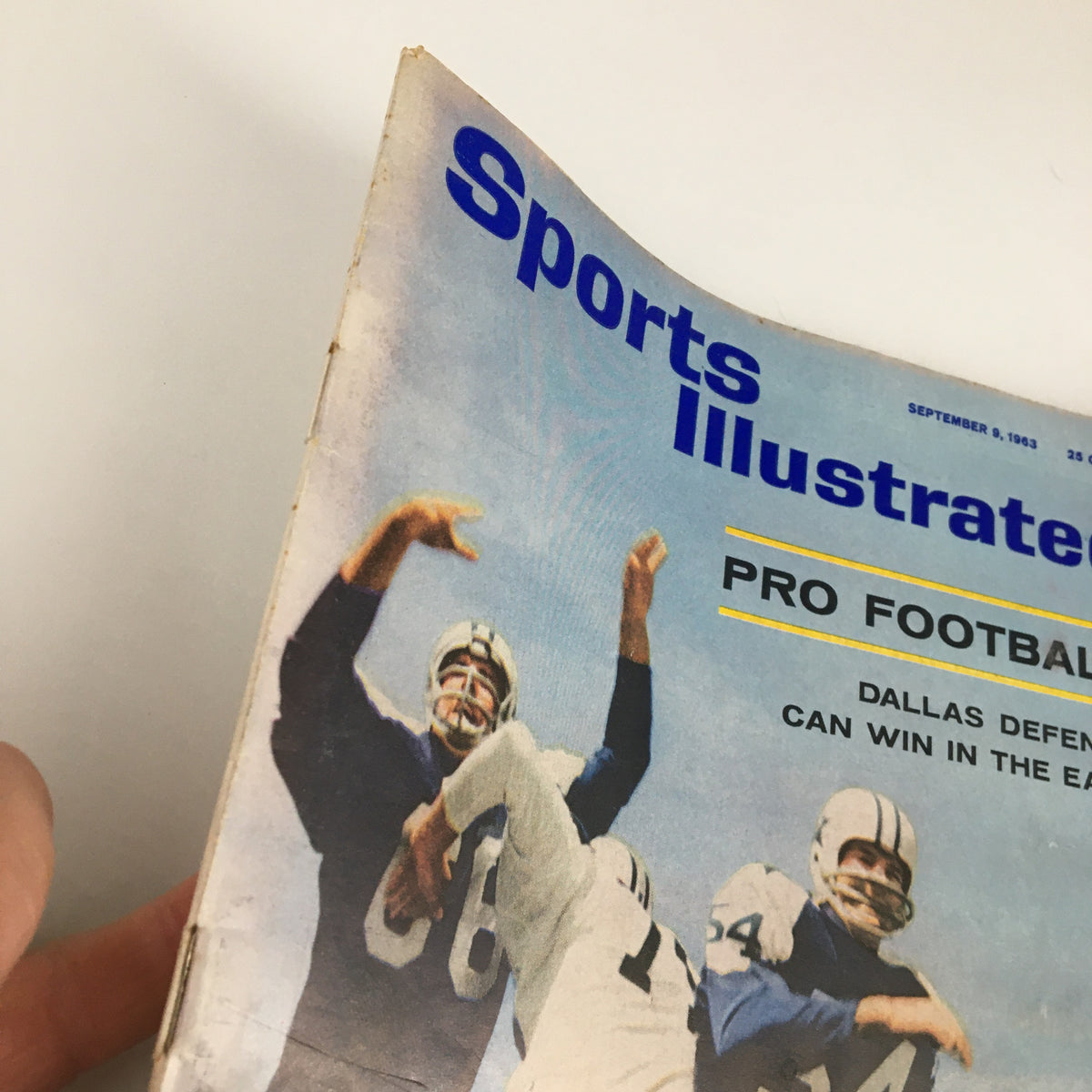 Close-up view of the Sports Illustrated magazine cover dated September 9, 1963, showcasing the headline 'Dallas Defense Can Win in East' with football players in action.