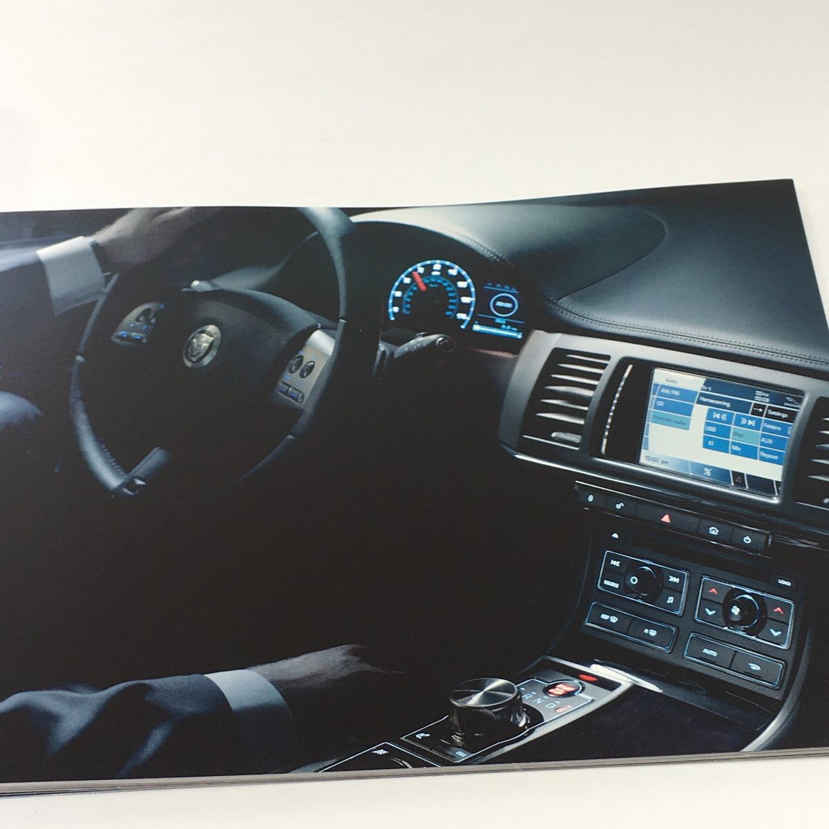 Interior view of the 2010 Jaguar The XF Collection car, showcasing the dashboard controls and steering wheel, featured in the dealership car auto brochure.