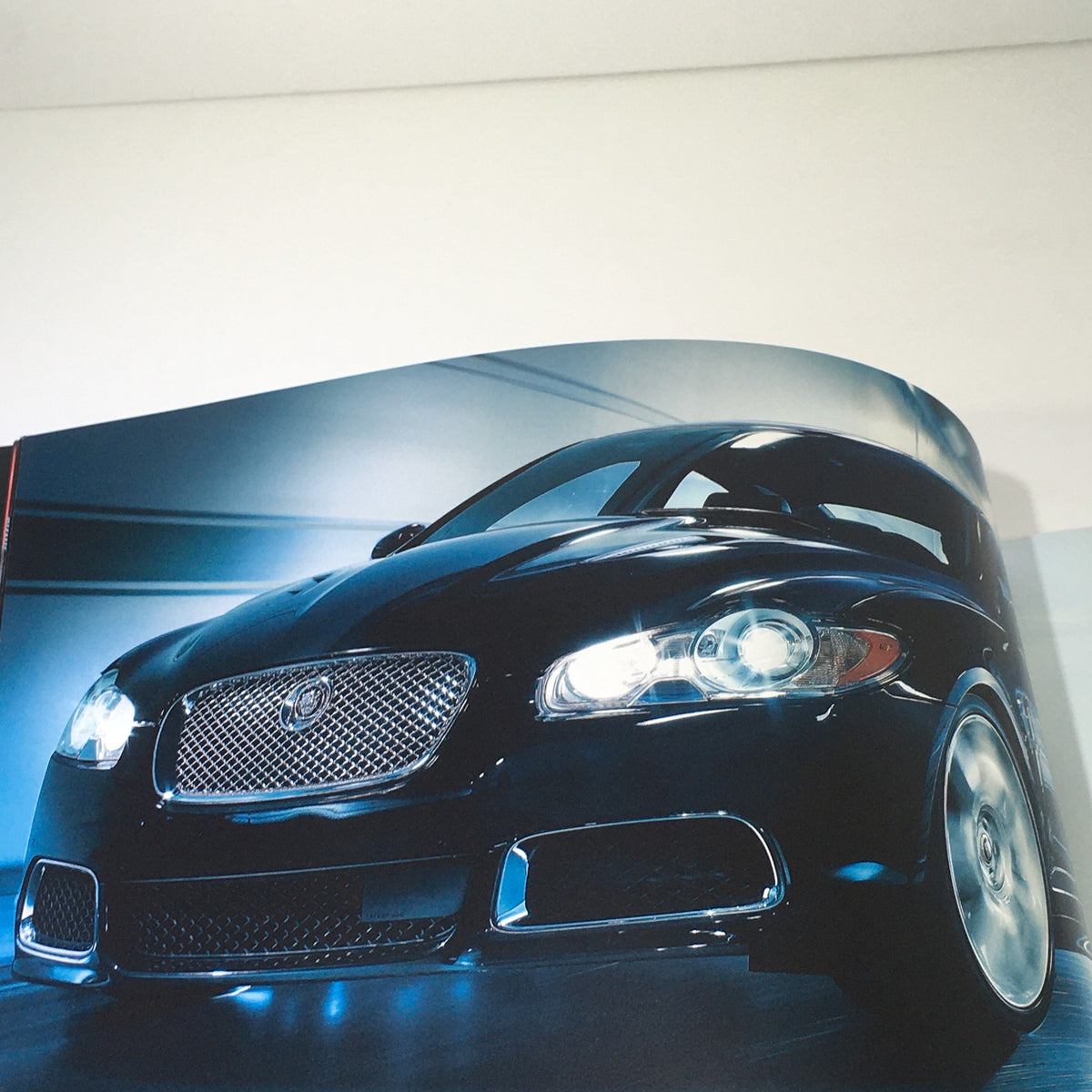 Sleek exterior shot of the 2010 Jaguar The XF Collection, highlighting its design and front grille, from the dealership car auto brochure.
