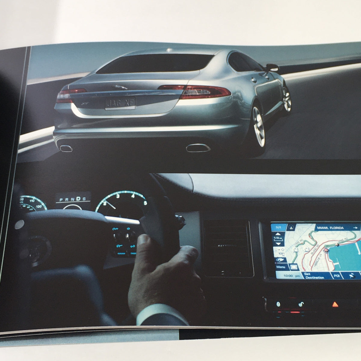 Rear view of the 2010 Jaguar The XF Collection in motion, displaying the car's features and dashboard controls, as seen in the dealership car auto brochure.