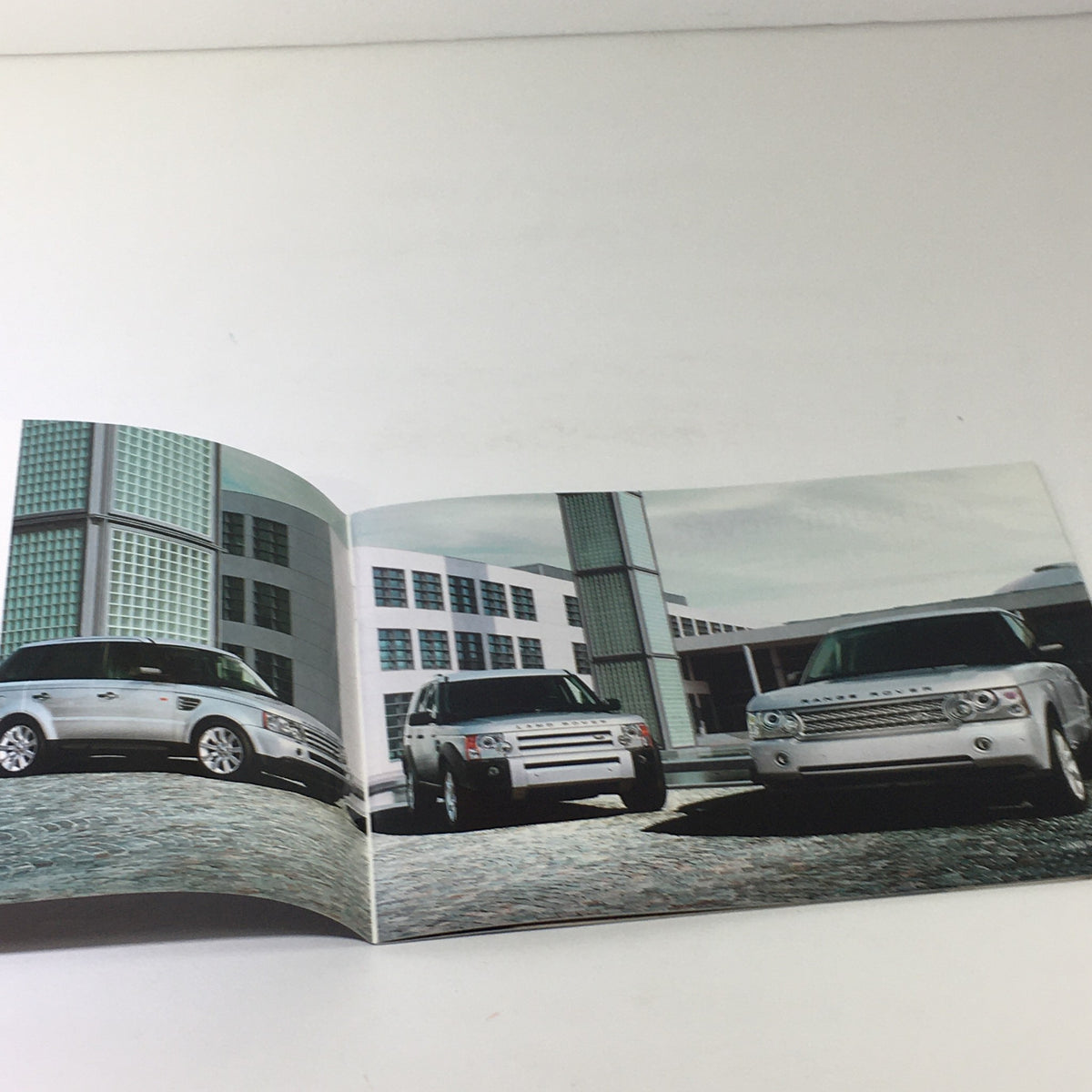 Inside view of the 2007 Land Rover American Cherry Dealership Car Auto Brochure showcasing multiple Land Rover models parked stylishly.