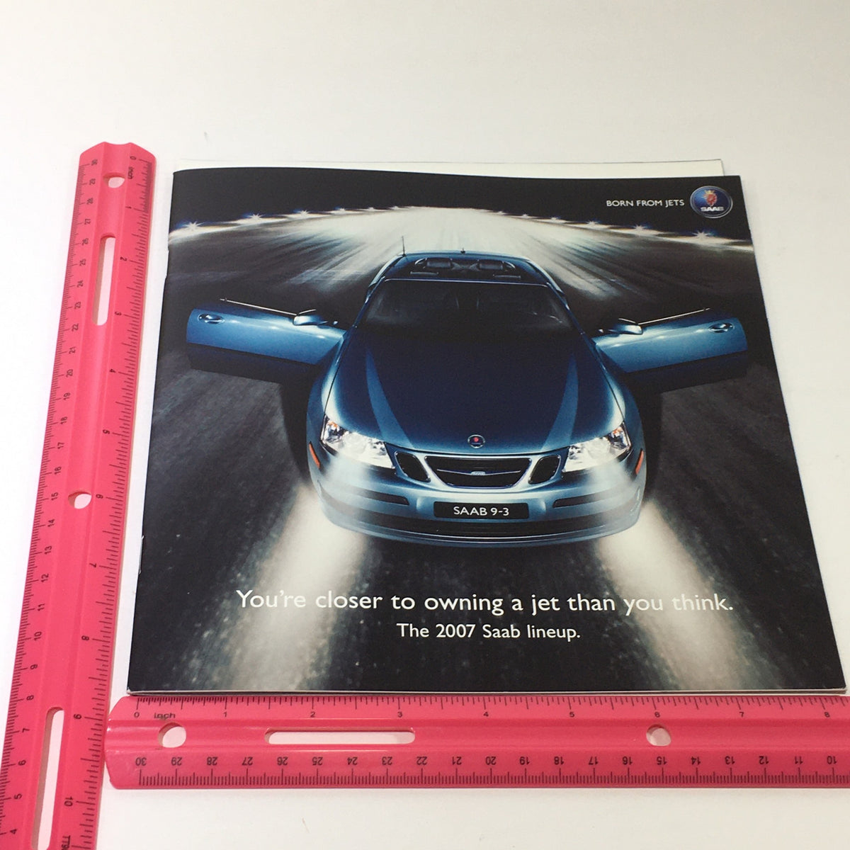 Front cover of the 2007 Saab Lineup 93 Sport Sedan Dealership Car Auto Brochure Catalog, featuring a blue Saab 9-3 car with open doors, promoting the tagline, 'You’re closer to owning a jet than you think.'