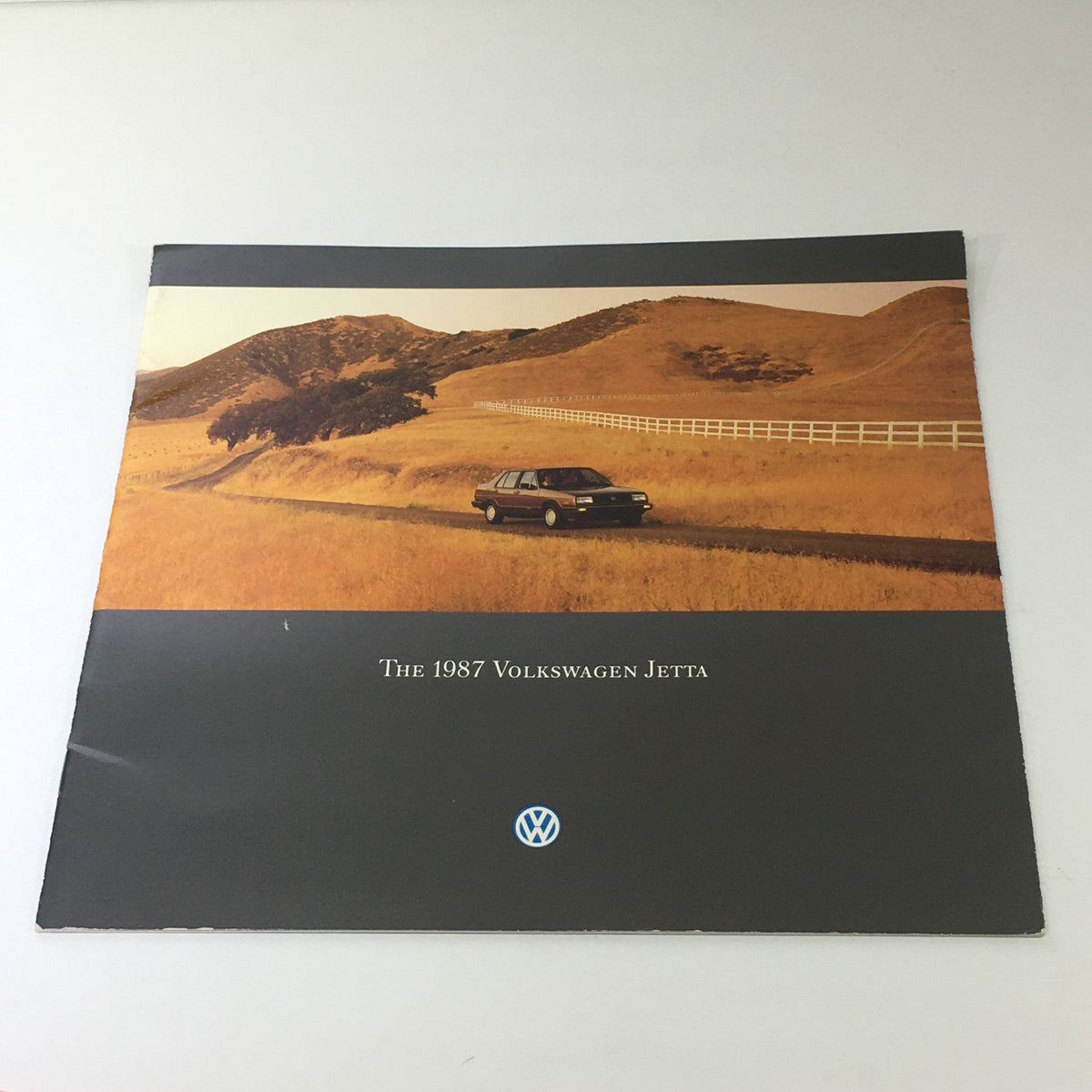 Cover page of the 1987 Volkswagen Jetta Fox Golf GTI Dealership Car Auto Brochure Catalog featuring a Volkswagen Jetta on a scenic road through golden fields.