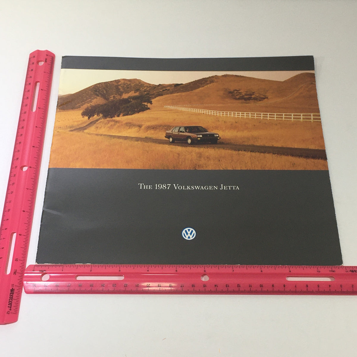 Another cover view of the 1987 Volkswagen Jetta brochure with a car parked in a picturesque landscape, highlighting the model as part of the Volkswagen Jetta Fox Golf GTI Dealership Car Auto Brochure Catalog.