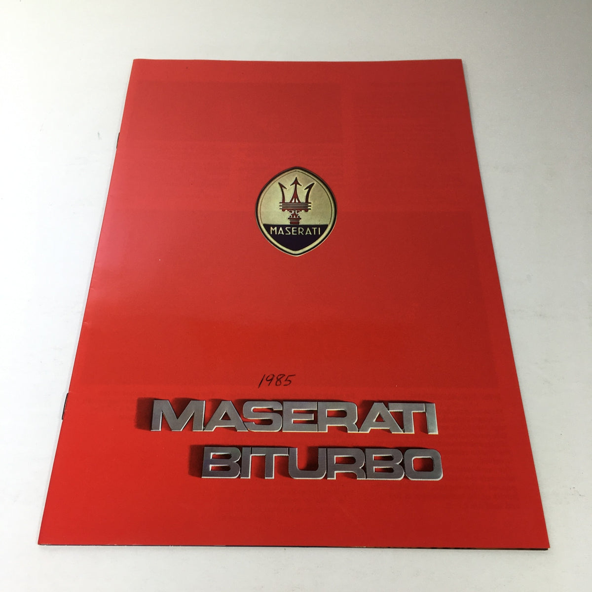 1985 Maserati Biturbo Dealership Car Auto Brochure Catalog cover featuring the Maserati logo and title on a red background.
