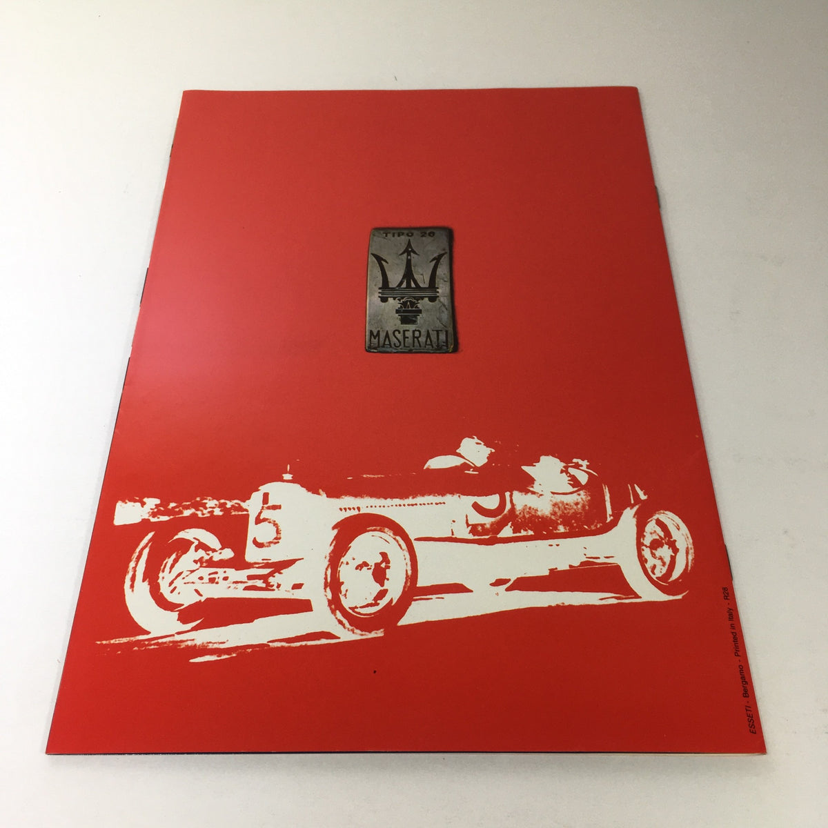 1985 Maserati Biturbo Dealership Car Auto Brochure Catalog cover showcasing a red design with a historic Maserati racing car illustration.