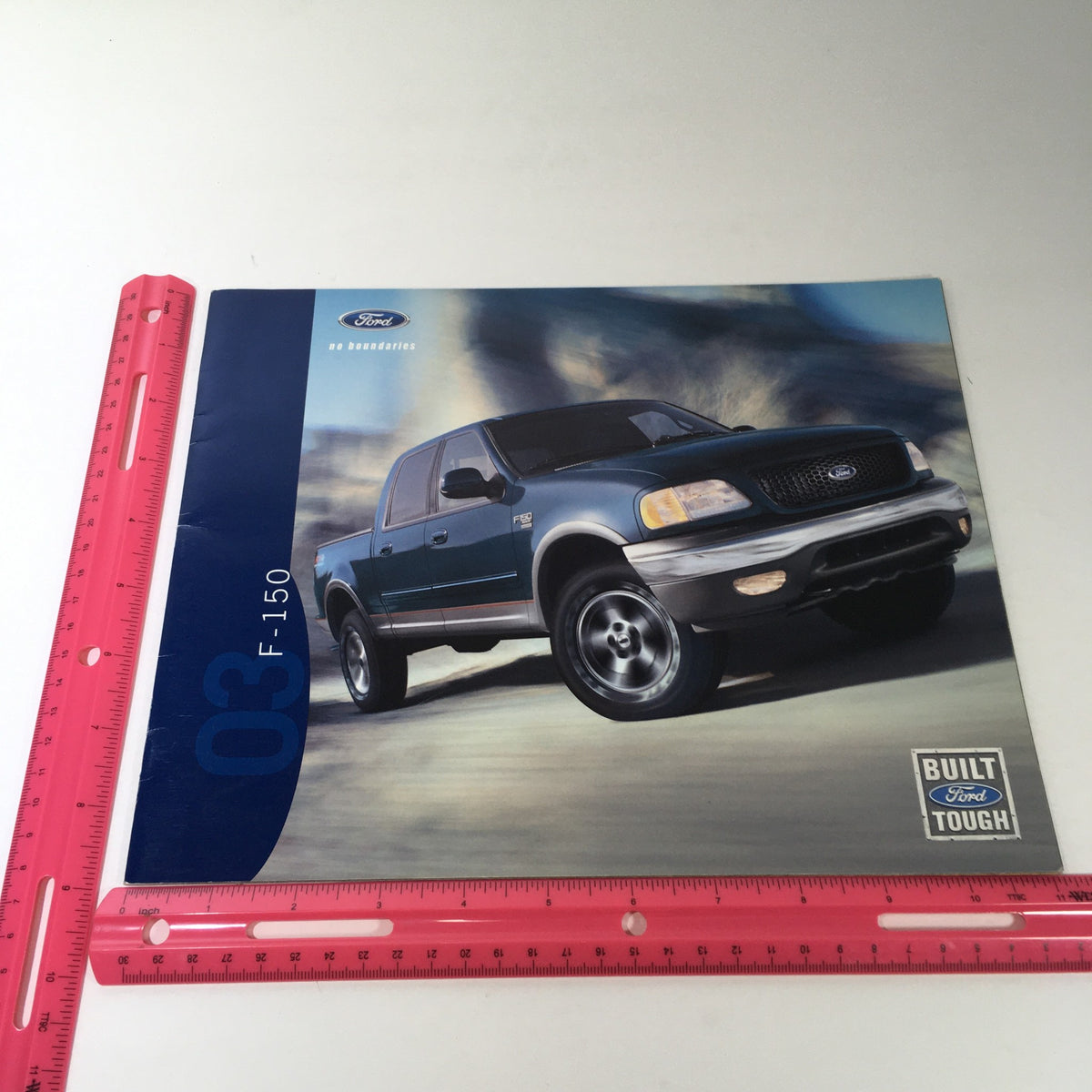 Cover of the 2003 Ford F-150 4x4 Pickup Dealership Car Auto Brochure Catalog, featuring a dynamic image of a green Ford F-150 on a stylized background, highlighting its rugged design and performance.