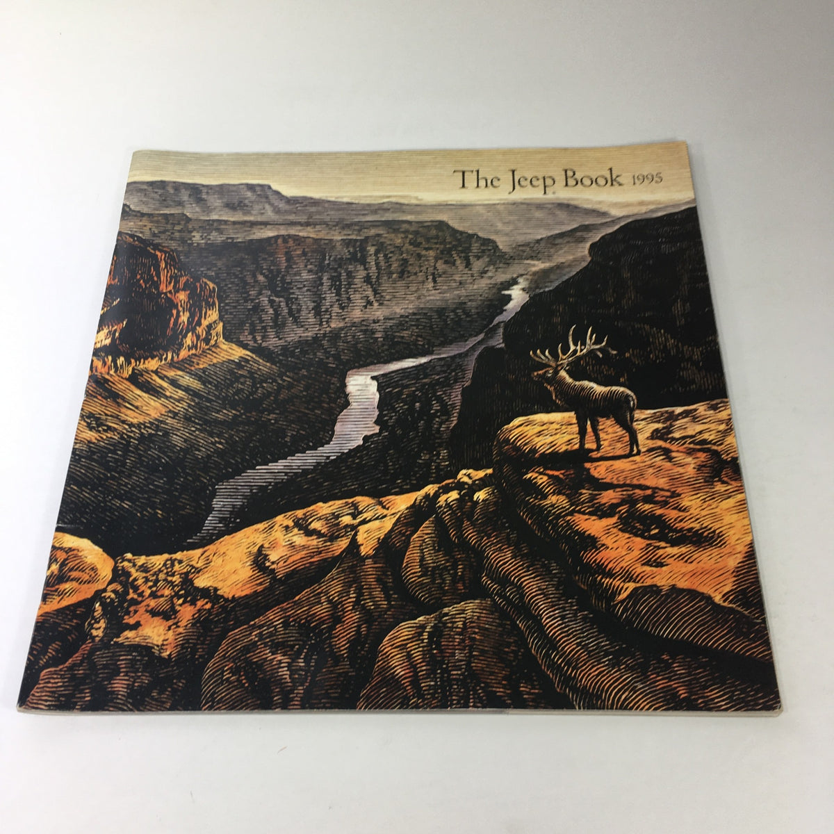 Cover of the 1995 The Jeep Book Dealership Car Auto Brochure Catalog featuring a landscape illustration with a deer on a cliff overlooking a scenic vista.