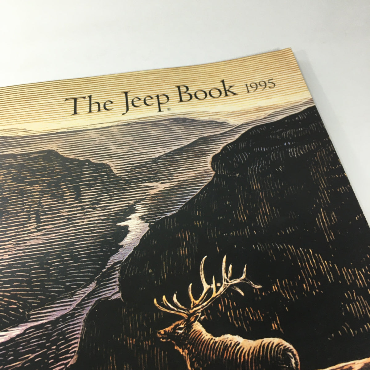 Cover of the 1995 The Jeep Book Dealership Car Auto Brochure Catalog featuring a scenic illustration of mountains and a deer.