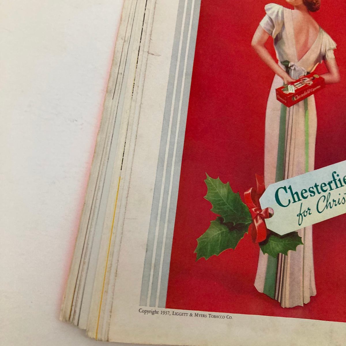 Close-up of a vintage advertisement for Chesterfield cigarettes from VTG Time Magazine December 13 1937 Vol 30 No. 24, featuring a woman in festive attire.