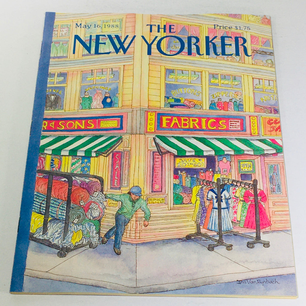 The New Yorker: May 16 1988 - Full Magazine cover featuring vibrant illustration by Iris Van Rynbach, showcasing a street scene with fabric shops and colorful merchandise.