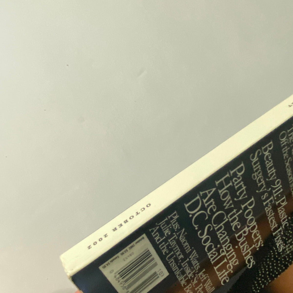 The spine of W Magazine October 2002 displaying the month and year along with the title, emphasizing its significance in fashion publication history.