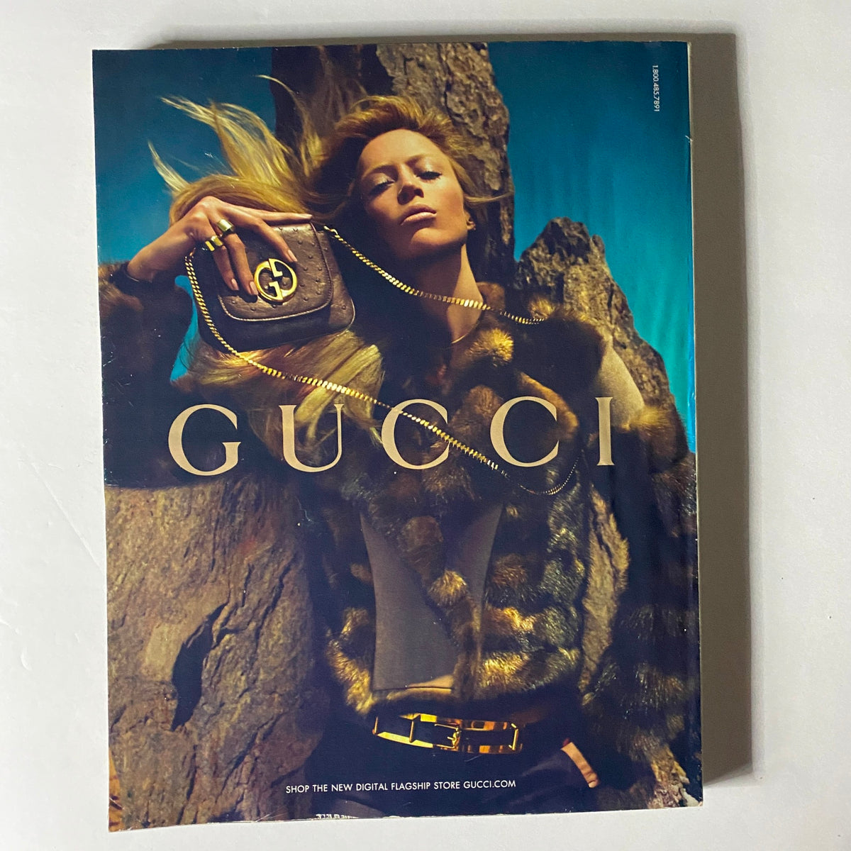 Fashion advertisement from W Magazine September 2010 featuring a striking image of a model in a Gucci outfit, showcasing fur and high-fashion aesthetics against a dramatic backdrop.
