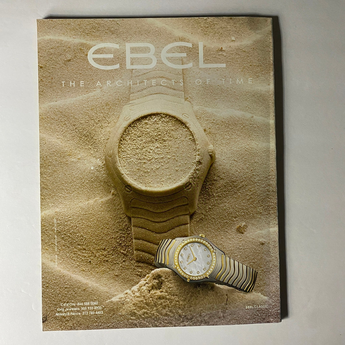 W Magazine June 2010 advertisement for Ebel watches, highlighting timeless elegance and design in a sandy backdrop.