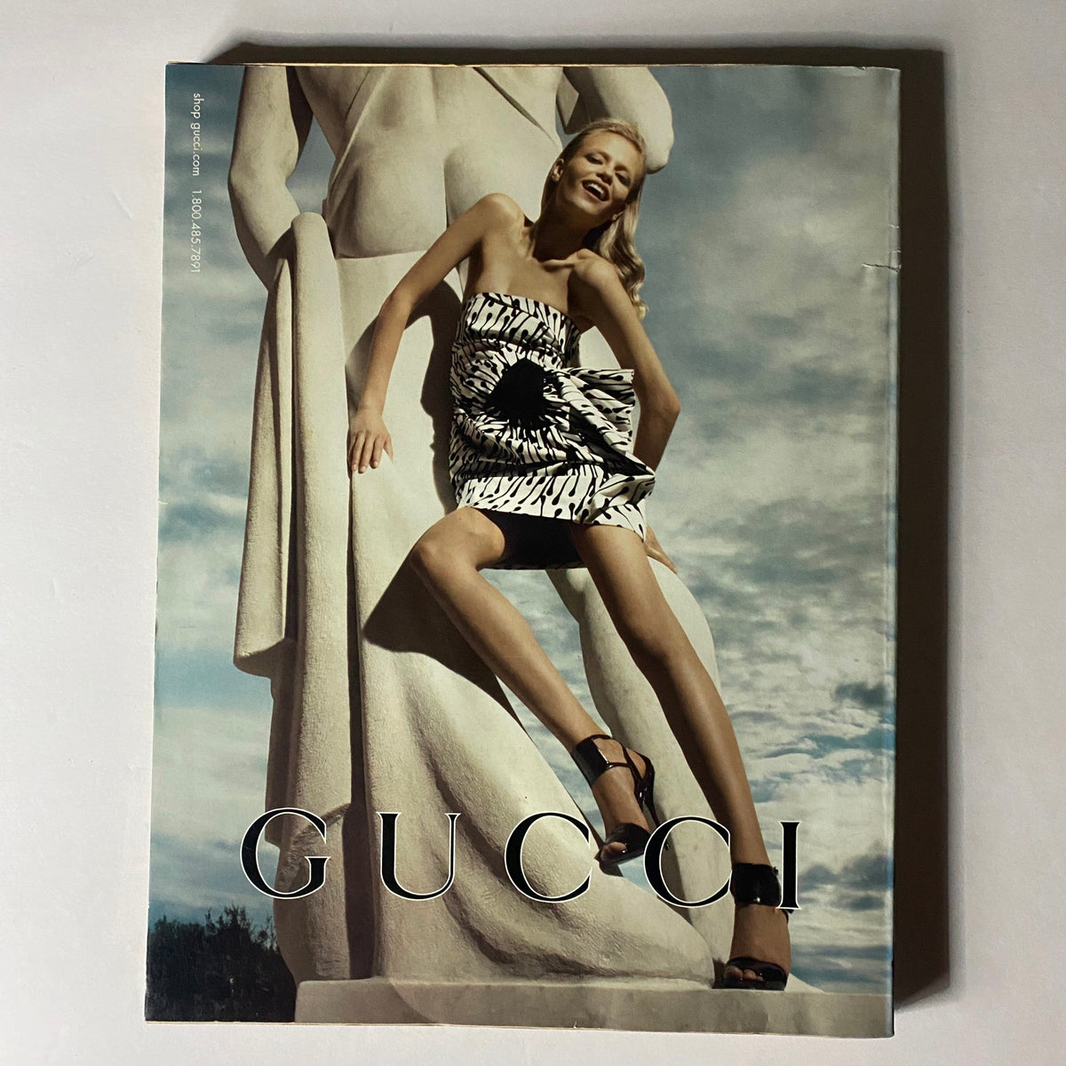 Cover of W Magazine April 2008 displaying a model in a striking Gucci dress posed against a classical statue under a dramatic sky.
