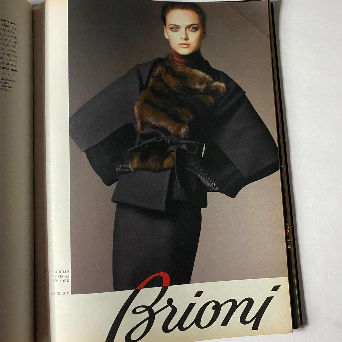 Chic fashion editorial from W Magazine October 2008, highlighting a model in a sophisticated fur-collared black coat styled by Brioni, epitomizing luxury in fashion.