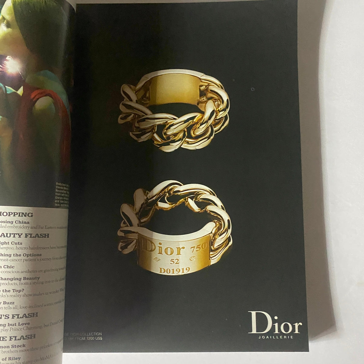 Dior jewelry advertisement for a gold ring collection featuring intertwined designs, showcasing luxury and elegance in high fashion. W Magazine October 2004.