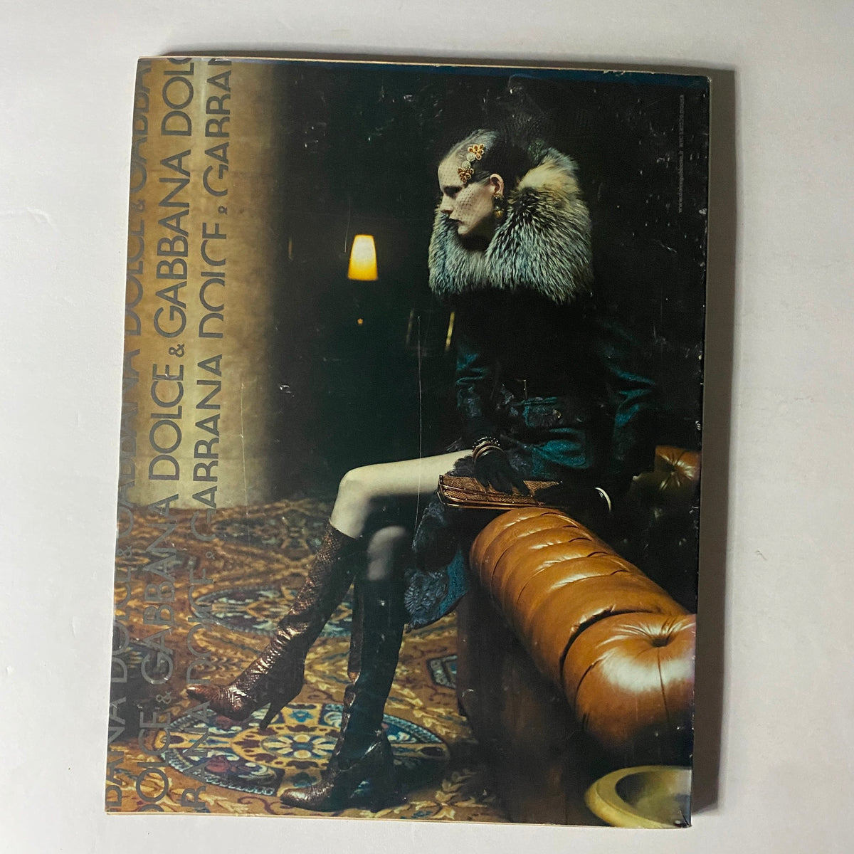 Back cover of W Magazine August 2004 showcasing a model dressed in high fashion by Dolce & Gabbana, featuring a fur collar and stylish boots.