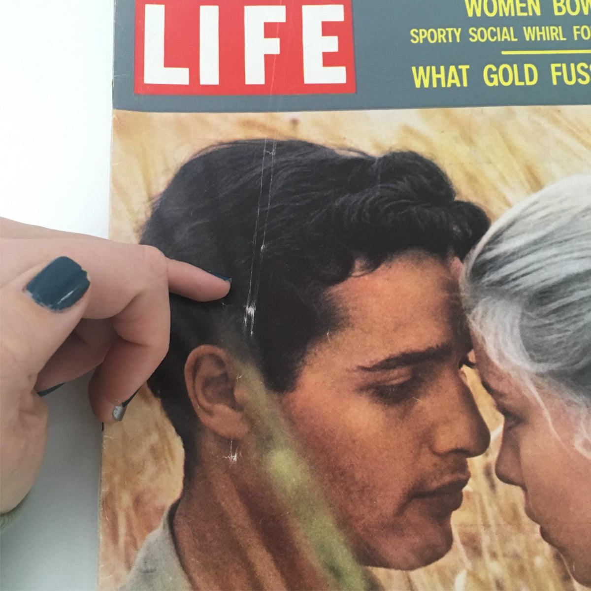 Zoomed-in view of the vintage Life Magazine cover from December 12, 1960, highlighting Jill Haworth and Sal Mineo's faces, with a gentle touch on the top edge, emphasizing wear in this collectible.