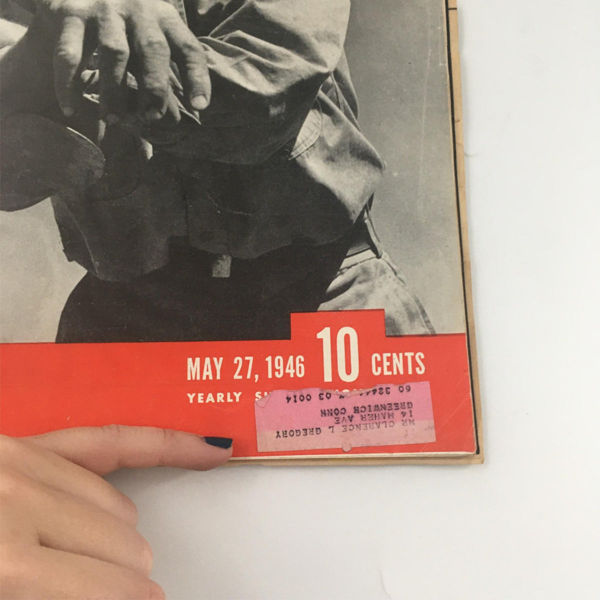 Close-up view of the cover of the May 27, 1946 Life Magazine highlighting Tom Moss, Ozark Farmer. The image shows a hand pointing at the date and price, with the cover prominently featuring the magazine's title and vibrant red accents.