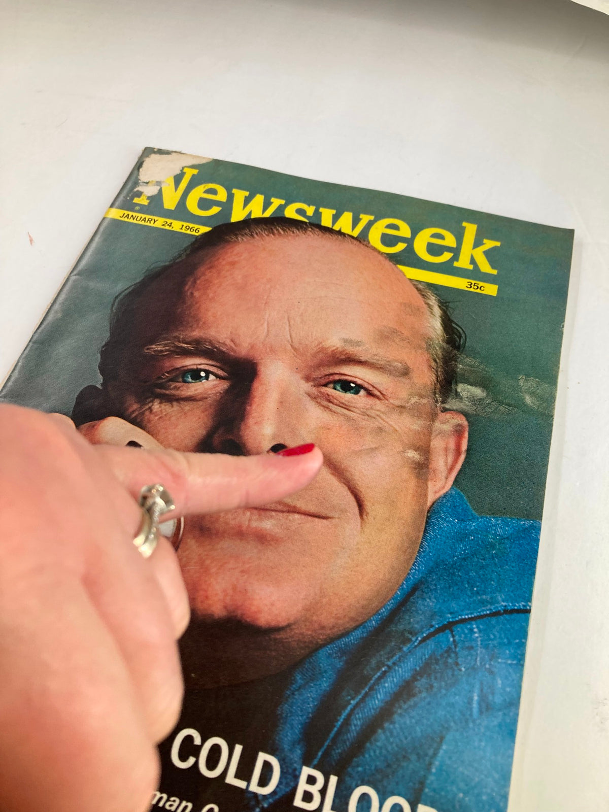 Detailed view of the vintage Newsweek magazine from January 24, 1966, featuring 'In Cold Blood' by Truman Capote. Highlights on the cover show text details and wearer on the magazine's front.