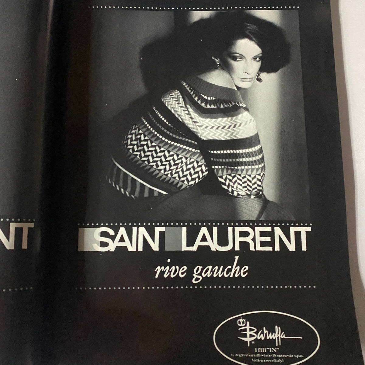 Vintage Saint Laurent advertisement featuring a glamorous model in a patterned sweater, showcasing the iconic fashion of the 1970s. Vogue Paris Magazine February 1977 Marcie Hunt by Guy Bourdin Cover No Label.