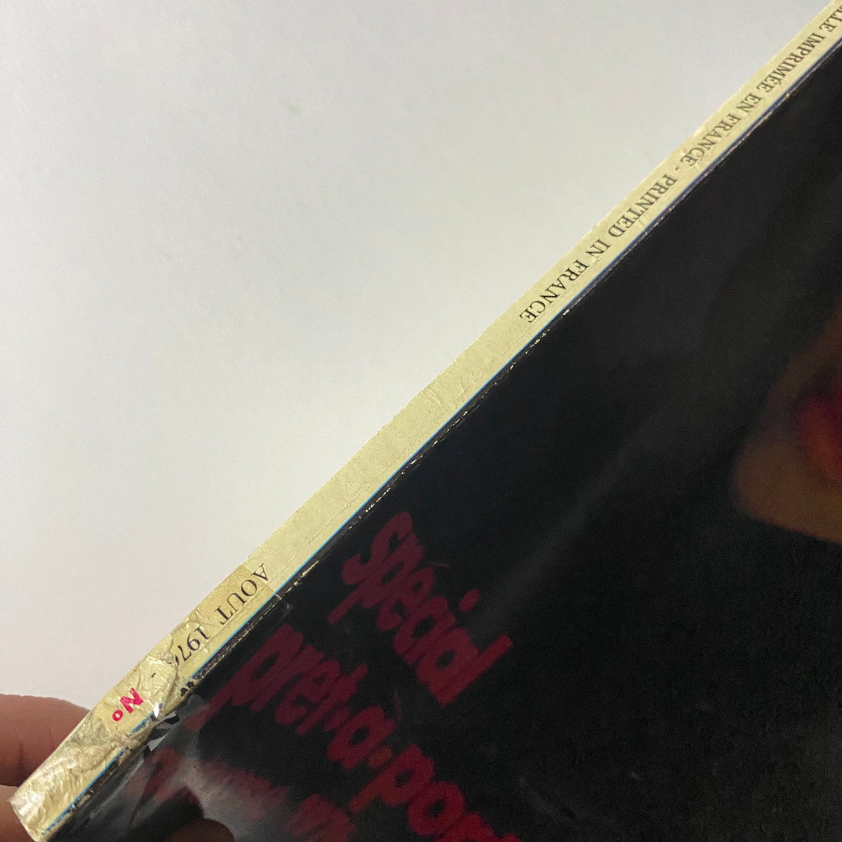 Side view of Vogue Paris Magazine August 1976 showing the spine and gold detailing, highlighting its vintage nature as a collectible item.