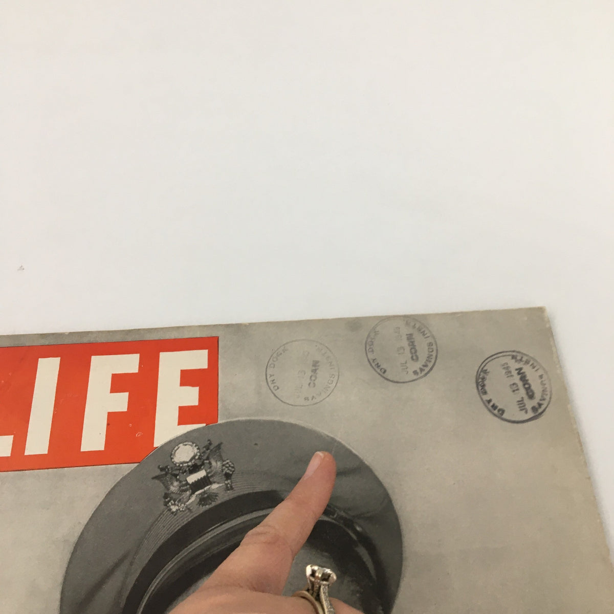 Close-up view of the VTG Life Magazine from July 16, 1945, showcasing the iconic red 'LIFE' title and post office stamps along the top of the cover. This historical magazine features Audie Murphy on the front, highlighting its collectible value.