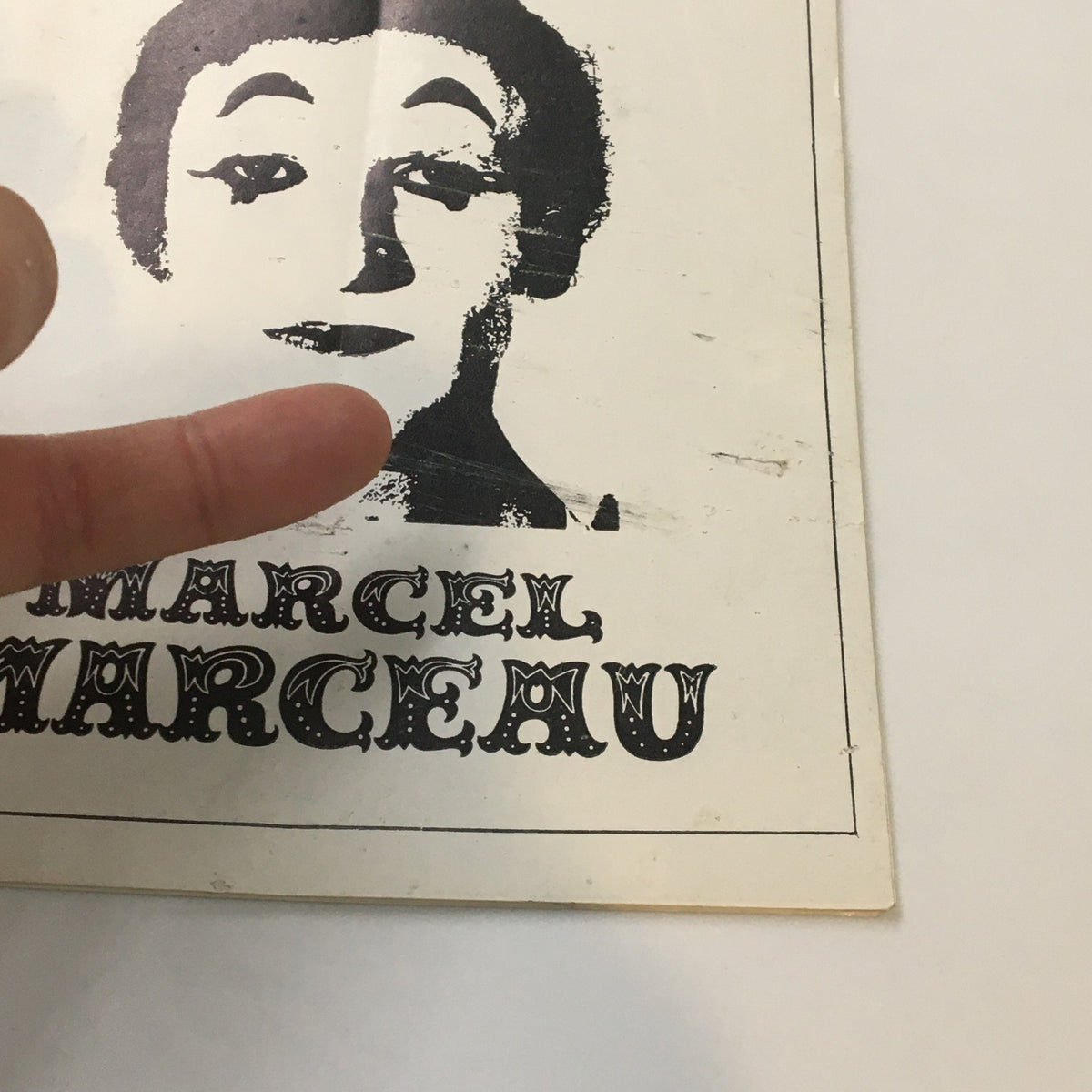 Close-up of the 1975 Playbill Shubert Theatre featuring Marcel Marceau, highlighting the cover with a finger pointing at the artwork.