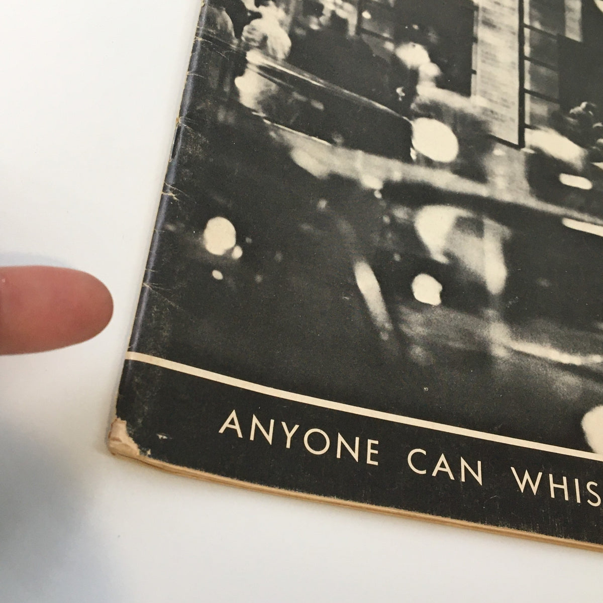Close-up of the cover of the 1964 Playbill for 'Anyone Can Whistle', highlighting its title in white letters against a vintage photographic background.