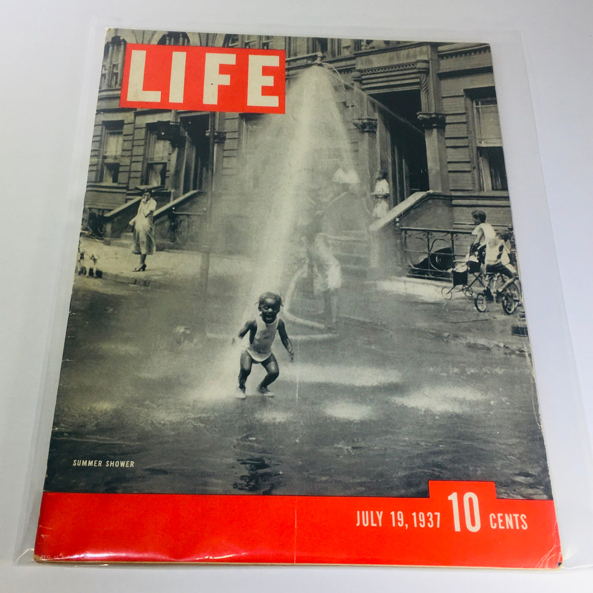 Cover of Vintage Life Magazine: July 19, 1937 - Summer Shower, featuring a child playing in water from a fire hydrant in an urban setting, showcasing summer leisure activities of the 1930s.