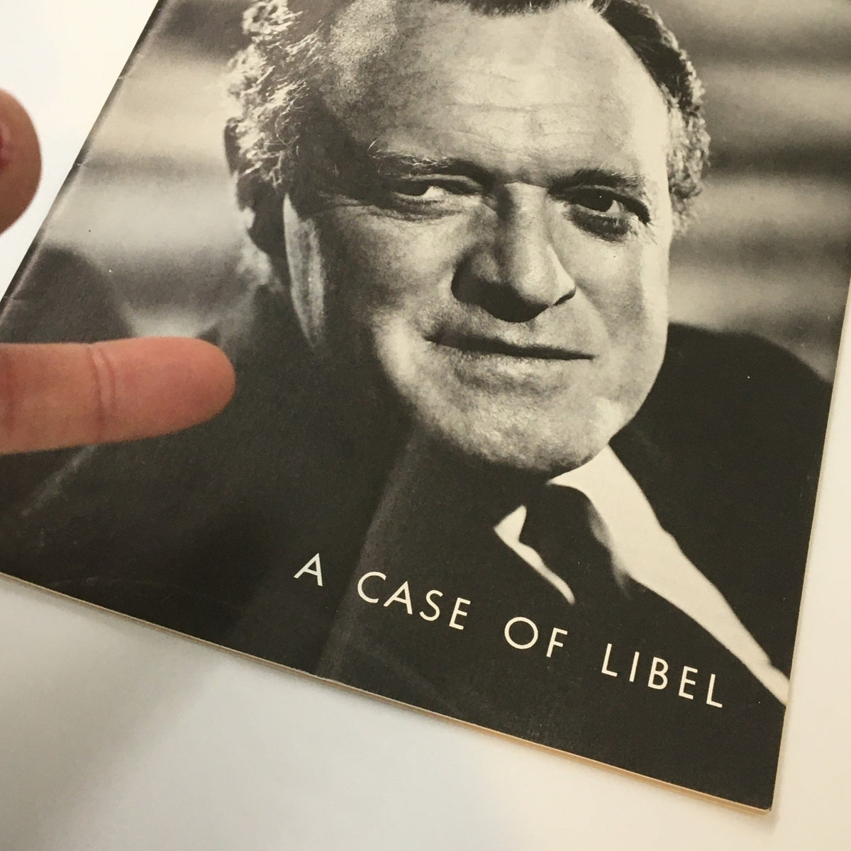 Close-up of the 1963 Playbill from Longacre Theatre for 'A Case of Libel' showing actor Van Helfin and a finger pointing at the cover.